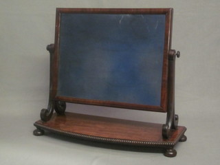 A 19th Century rectangular plate mirror contained in a mahogany swing frame raised on a bow front base 24"
