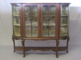 An Edwardian mahogany bow front display cabinet fitted shelves enclosed by glazed doors, raised on cabriole supports 54"