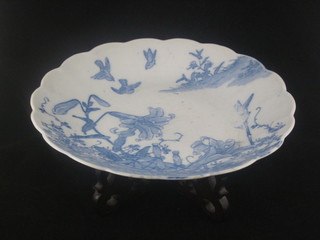 An Oriental blue and white porcelain dish decorated birds and flowers with scalloped edge 12", raised on a carved hardwood  stand 10"