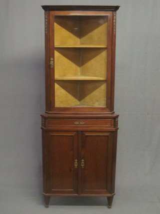 A Continental mahogany double corner cabinet, the upper section  with moulded cornice, the interior fitted shelves with gilt metal  mounts, the base fitted a drawer above a double cupboard, raised  on square tapering supports 26"