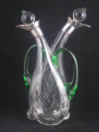An Edwardian clear glass double decanter with green glass  handles and silver mounts  ILLUSTRATED