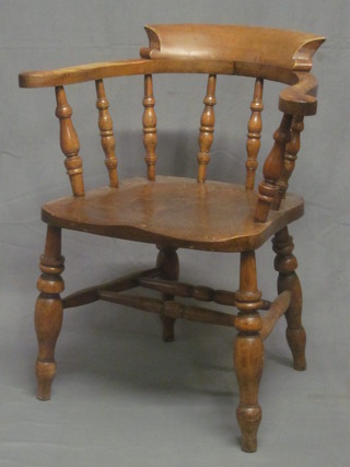 An elm Captain's chair raised on turned supports with H framed stretcher