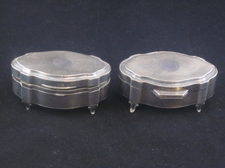 A pair of oval shaped silver trinket boxes with hinged lids, raised on panel supports, Birmingham 1923, 3", 1 leg f,