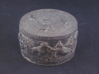 An Eastern cylindrical embossed white metal jar and cover  decorated animals