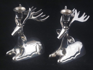 A pair of novelty silver plated candlesticks in the form of seated reindeer 7"