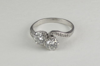 A platinum cross-over dress ring set 2 diamonds and with diamonds to the shoulders