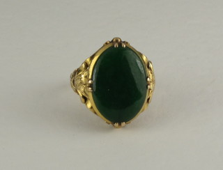 A lady's gold dress ring set an oval green hardstone