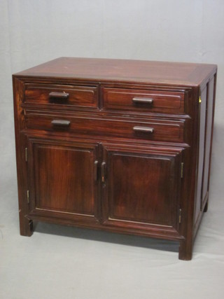 An Oriental Padouk cabinet fitted 2 short and 1 long drawer  above a double cupboard 34"
