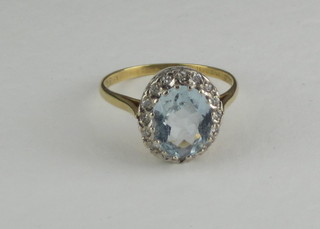 A gold dress ring set an oval cut aquamarine surrounded by  diamonds
