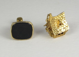 A gold charm in the form of a house together with a gold seal