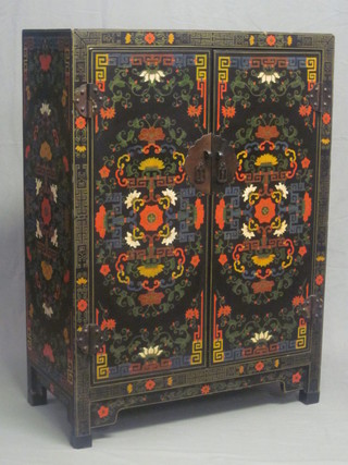 An Eastern black lacquered cabinet with shelved interior enclosed  by panelled doors 31"  ILLUSTRATED