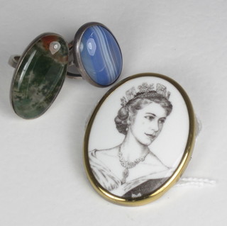A pair of silver rings set polished hardstones together with a porcelain portrait brooch of HM The Queen