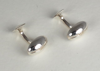 A pair of silver cufflinks in the form of rugby balls