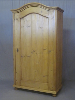 A Continental stripped and polished pine cupboard the interior fitted shelves, enclosed by an arched panelled door 40"