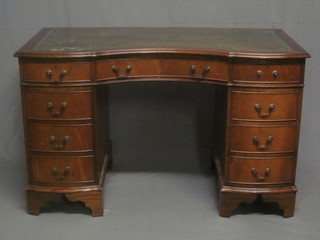 A Georgian style mahogany kneehole pedestal desk with concave  shaped top inset a green leather writing surface, fitted 1 long  drawer flanked by 8 short drawers 48"