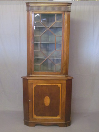 A 19th Century inlaid mahogany double corner cabinet the upper section with moulded and fluted cornice, the interior fitted  shelves enclosed by an astragal glazed panelled door, the base  fitted a cupboard enclosed by a panelled door, raised on bracket  feet 34"
