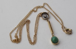 A gold pendant set a diamond and a cabouchon cut turquoise  hung on a fine gold chain