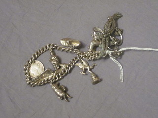 A silver curb link charm bracelet hung various charms and a  brooch