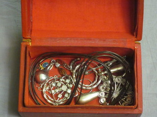 A red leather dome shaped jewellery box containing a collection of silver costume jewellery including earrings