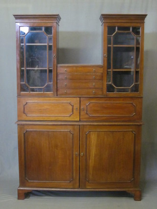 An Edwardian mahogany display cabinet on cabinet, the upper section fitted 4 short drawers flanked by a pair of sentry box  cabinets with moulded and dentil cornices, the interior fitted  adjustable shelves enclosed by astragal glazed doors, the base  fitted 2 further cupboards enclosed by panelled doors, raised on  bracket feet, made by Messrs Pragnel & Co of 50a East Street of  Horsham, together with a letter dated 1930, 45"