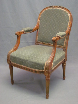 A carved walnut show frame open arm chair, upholstered in  green material, raised on turned and fluted supports