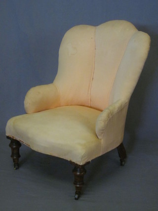 A Victorian mahogany framed armchair upholstered in pink material, raised on turned supports ending in brass castors