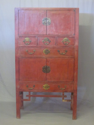 An Oriental red lacquered cabinet fitted a cupboard above 3 short and 1 long drawer, above a further cupboard and 1 long drawer,  37"