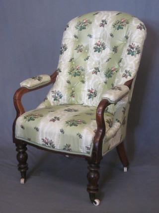 A Victorian mahogany open arm chair upholstered in green floral  material