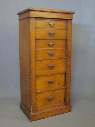 An Edwardian honey oak Wellington chest of 7 long drawers 22"