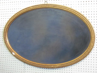 An oval bevelled plate wall mirror contained in a decorative gilt  frame 30"