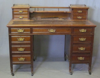 An Edwardian walnut pedestal desk with raised back, fitted 2 drawers and a brass three-quarter gallery, inset a tooled leather  writing surface, the base with 8 short drawers, 48"