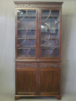 An Edwardian Chippendale style mahogany bookcase, the upper  section with moulded cornice, fitted adjustable shelves enclosed  by astragal glazed panelled doors, the base fitted 2 long drawers  above a double cupboard, raised on bracket feet 42"