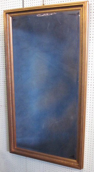 A rectangular bevelled plate wall mirror contained in a decorative  gilt frame 51"