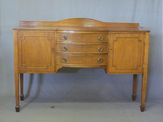 An Edwardian inlaid mahogany bow front sideboard with raised back, fitted 3 drawers flanked by a pair of cupboards, raised on  square supports ending in spade feet 60"