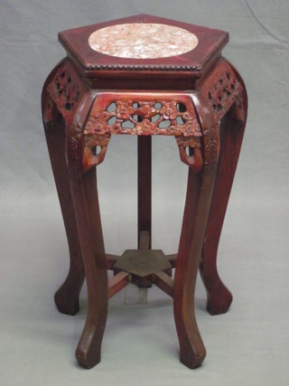 An Oriental octagonal pierced Padouk jardiniere stand with pink  veined marble top, raised on cabriole supports, 12"