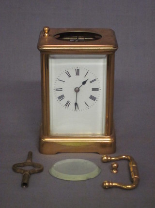 A French 8 day striking carriage clock with enamelled dial, contained in a gilt metal case, glass missing from top and handle  loose,