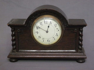 A French bedroom timepiece with enamelled dial and Arabic numerals, contained in an oak arch shaped case 9"