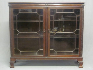 A Chippendale style display cabinet the interior fitted adjustable  shelves enclosed by astragal glazed panelled doors, raised on  bracket feet 54"