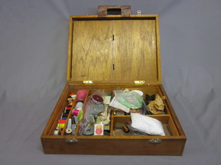 A wooden box containing various fly tying equipment