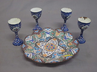 A Persian circular enamelled dish 8" together with 4 egg cups,  some chips,