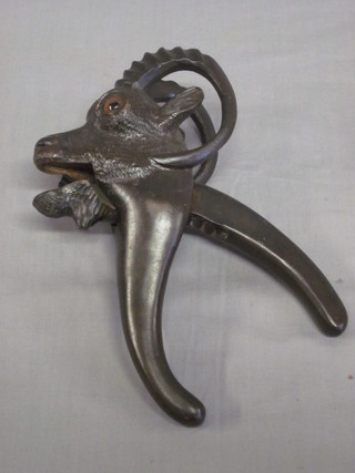 A pair of carved hardwood nut crackers in the form of a goats mask