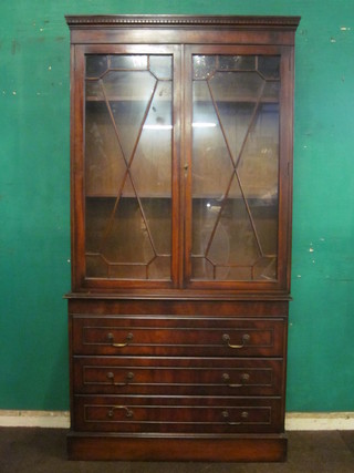 A Georgian style mahogany bookcase on chest, the upper section with moulded and dentil cornice, the interior fitted adjustable  shelves enclosed by astragal glazed panelled doors, the base fitted  4 long drawers, 39"