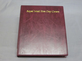 A Royal Mail red loose leaf album of first day covers and a green ditto