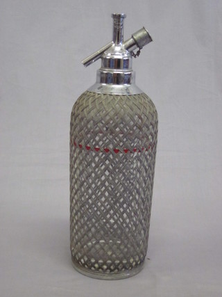 A glass and mesh covered soda siphon, handle f,