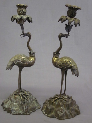 A pair of Eastern gilt bronze candlesticks supported by a figure of a stork 15"