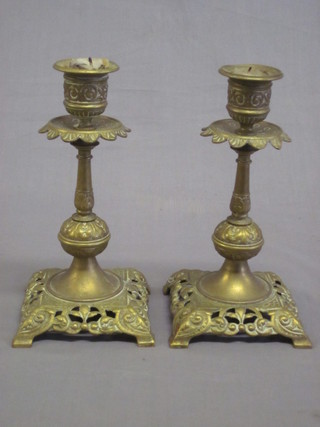 A pair of Victorian pierced brass candlesticks, raised on square  bases 6"