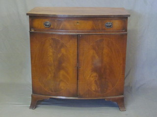 An Edwardian inlaid mahogany bow front side table, fitted a  drawer above a double cupboard, raised on splayed bracket feet  33"