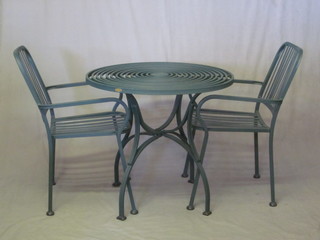 A green painted railed garden suite comprising circular pierced  metal table 31 1/2" and a pair of open armchairs