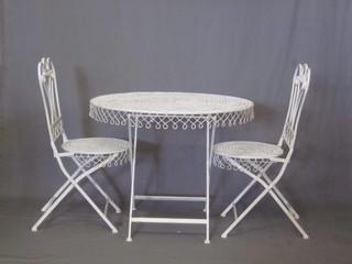 A garden suite comprising circular pierced iron folding table 36"  and a set of 4 folding chairs