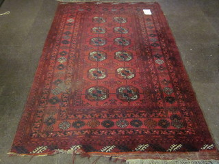 A red Afghan rug with 12 octagons to the centre, soiled, 77" x  51"